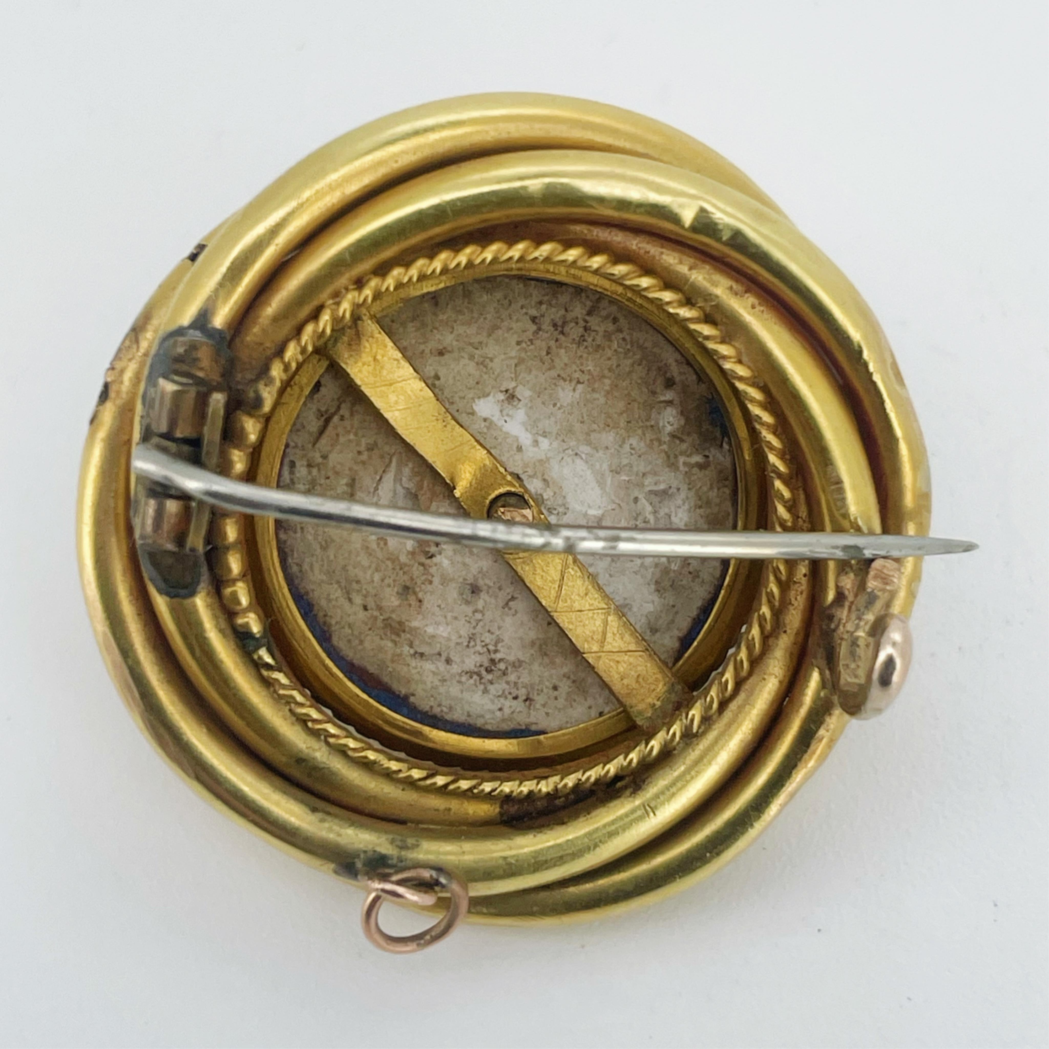 A Victorian gold, enamel, opal and diamond brooch, mid 19th century, of circular outline, the domed centre set with a cabochon opal surrounded by rose-cut diamonds, within a six-rayed star motif in blue enamel, to a bord